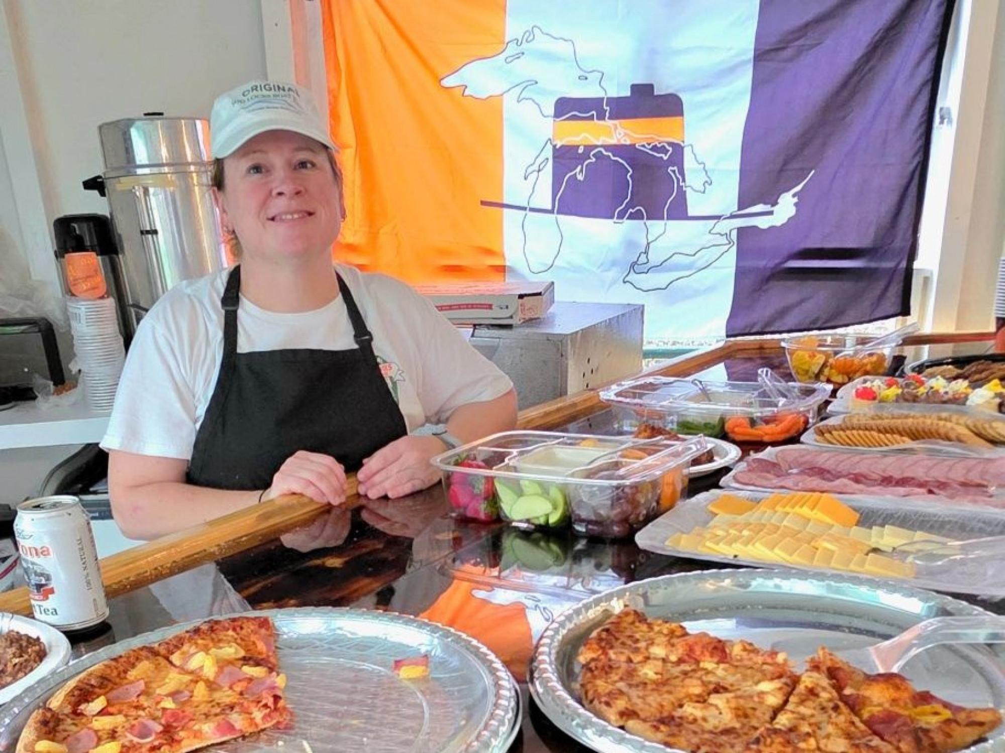 Crew member serving pizza and appetizers during an Original Soo Locks Boatnerd Cruise in Sault Ste. Marie, Michigan, sponsored by Interlake Steamship Company and Domino’s Pizzae