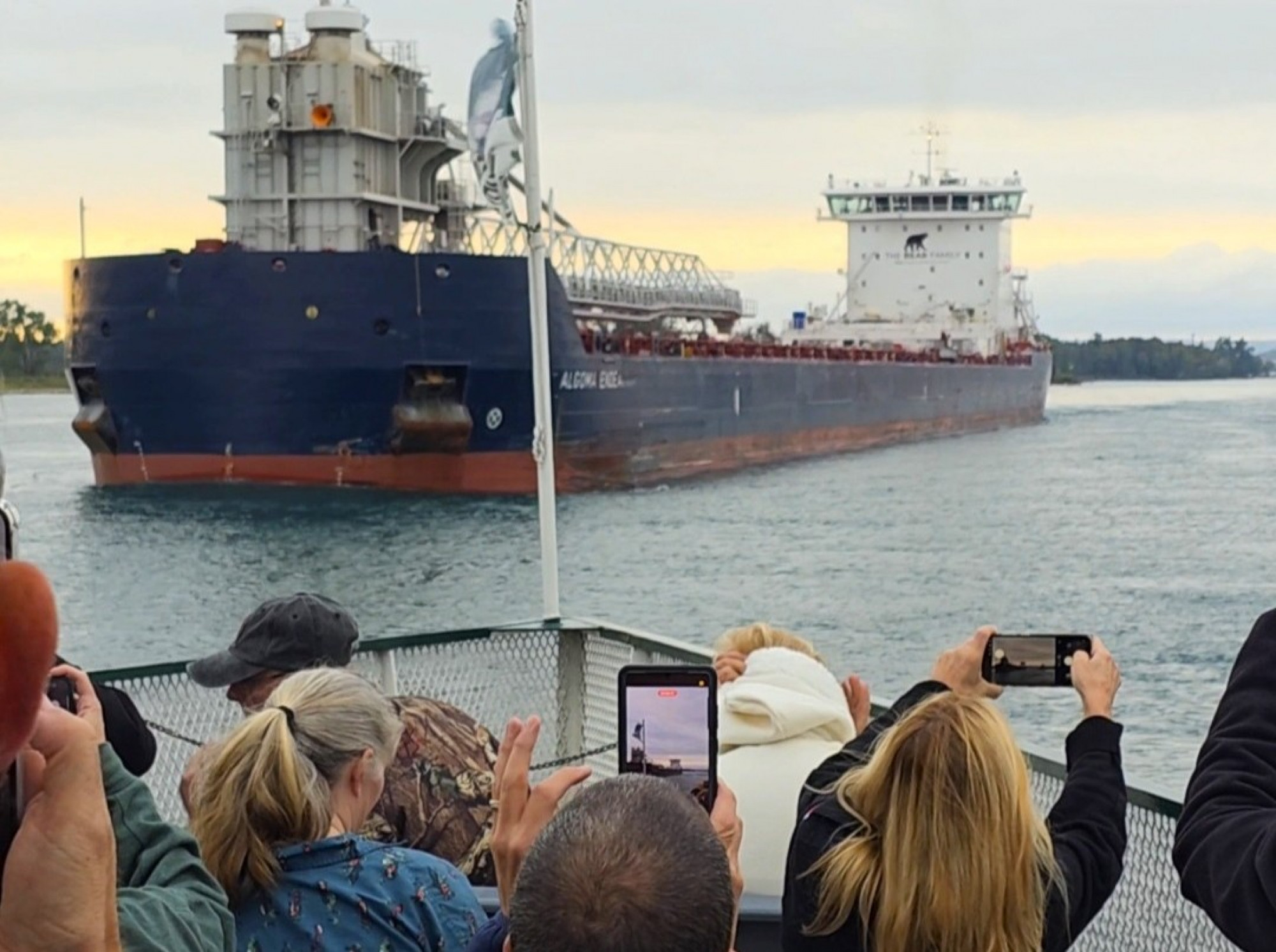 Passengers on deck watching the Great Lakes freighter Algoma Endeavour and exchanging captain’s salutes during an Original Soo Locks Boatnerd Cruise in Sault Ste. Marie, Michigan