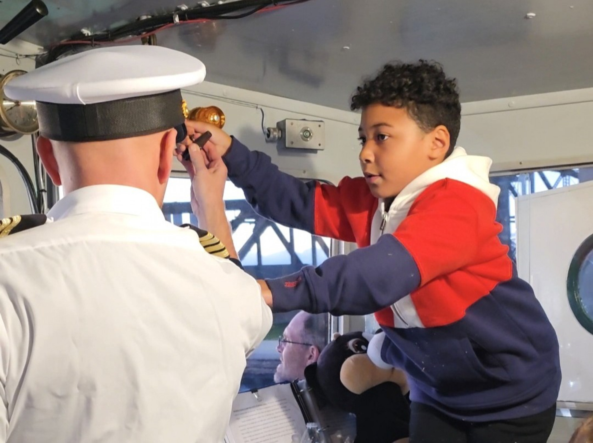 Young guest Mason helping at the helm and exchanging the master salute with the Great Lakes freighter Joseph L. Block during an Original Soo Locks Boatnerd Cruise in Sault Ste. Marie, Michigan