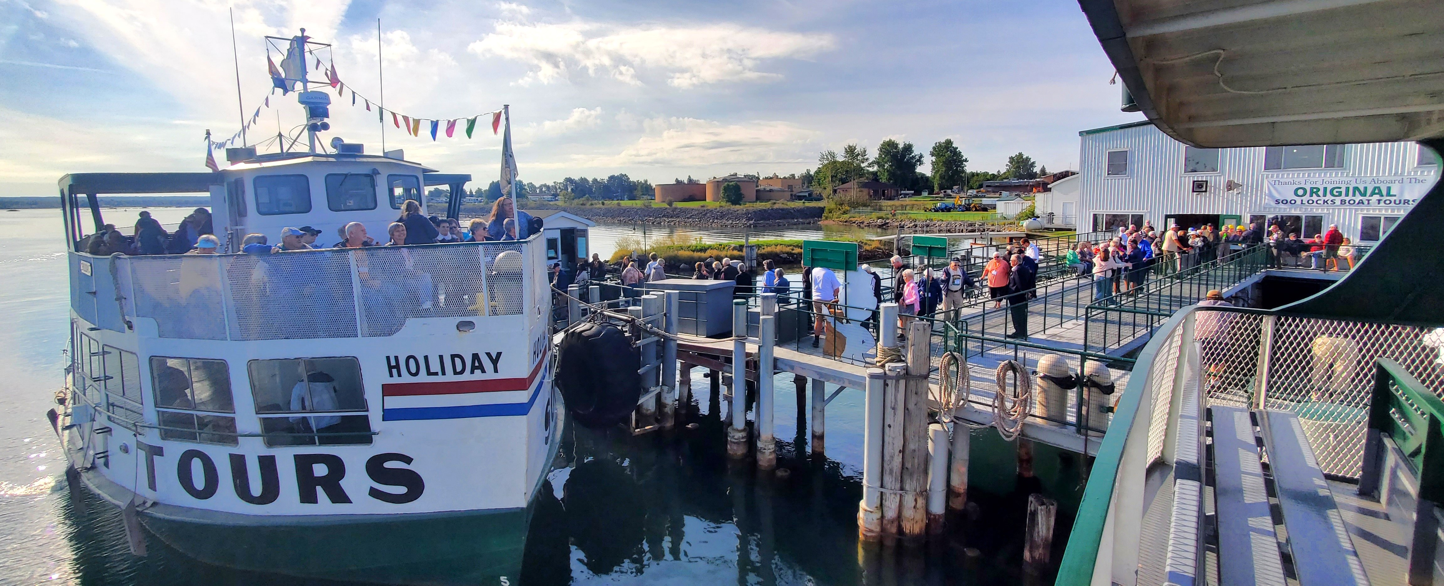 Motorcoach group boarding the tour boat Holiday at Original Soo Locks Boat Tours.