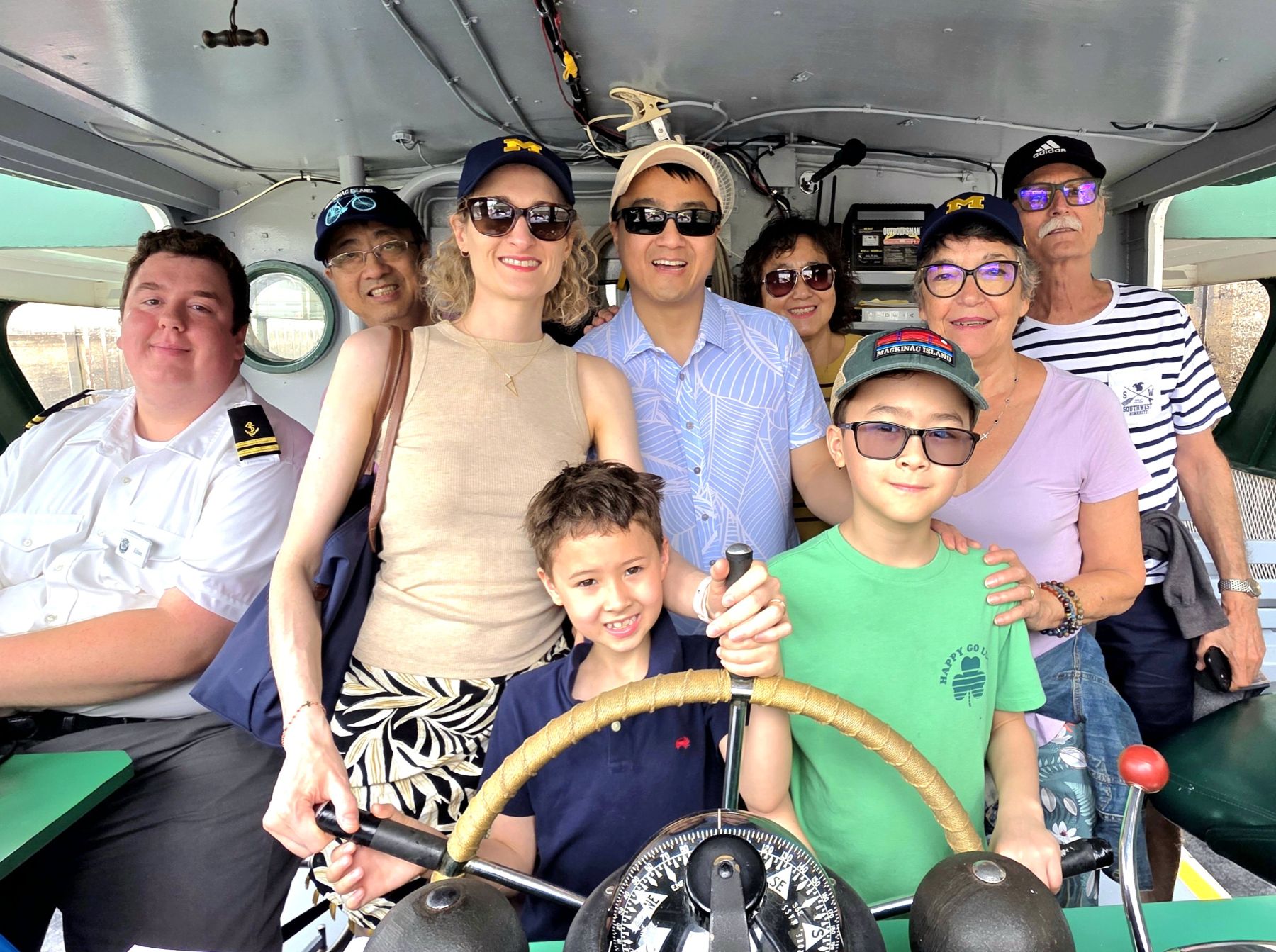 Michigan's Upper Peninsula Soo Locks Boat Tours family at the helm in the pilot house having fun with the Original Soo Lock Tours