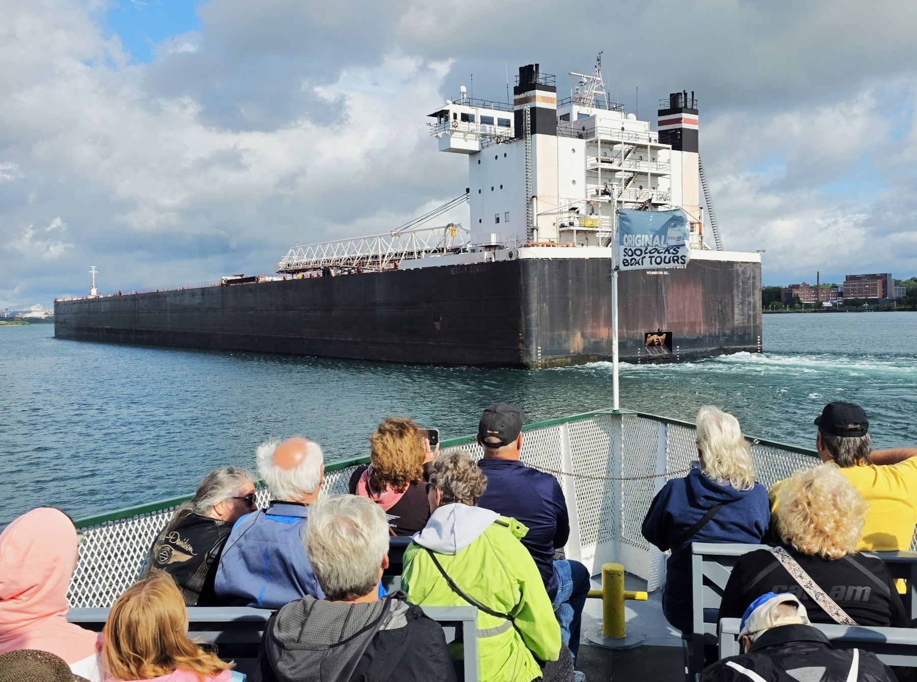 Michigan's Upper Peninsula Soo Locks Tours with guest on deck watching a 1000-foot freighter head into the Soo Locks