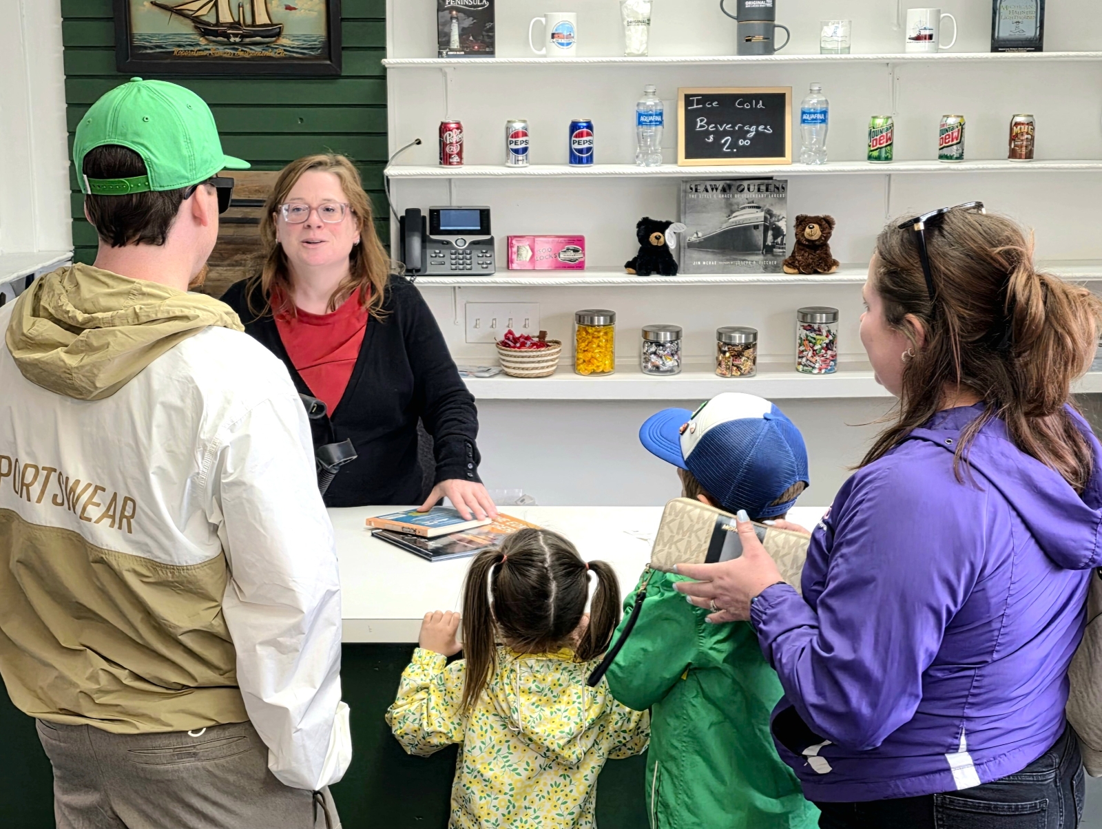 Family fun and kids excited at the counter purchasing mementoes inside the Original Soo Locks Boat Tours gift shop in Sault Michigan